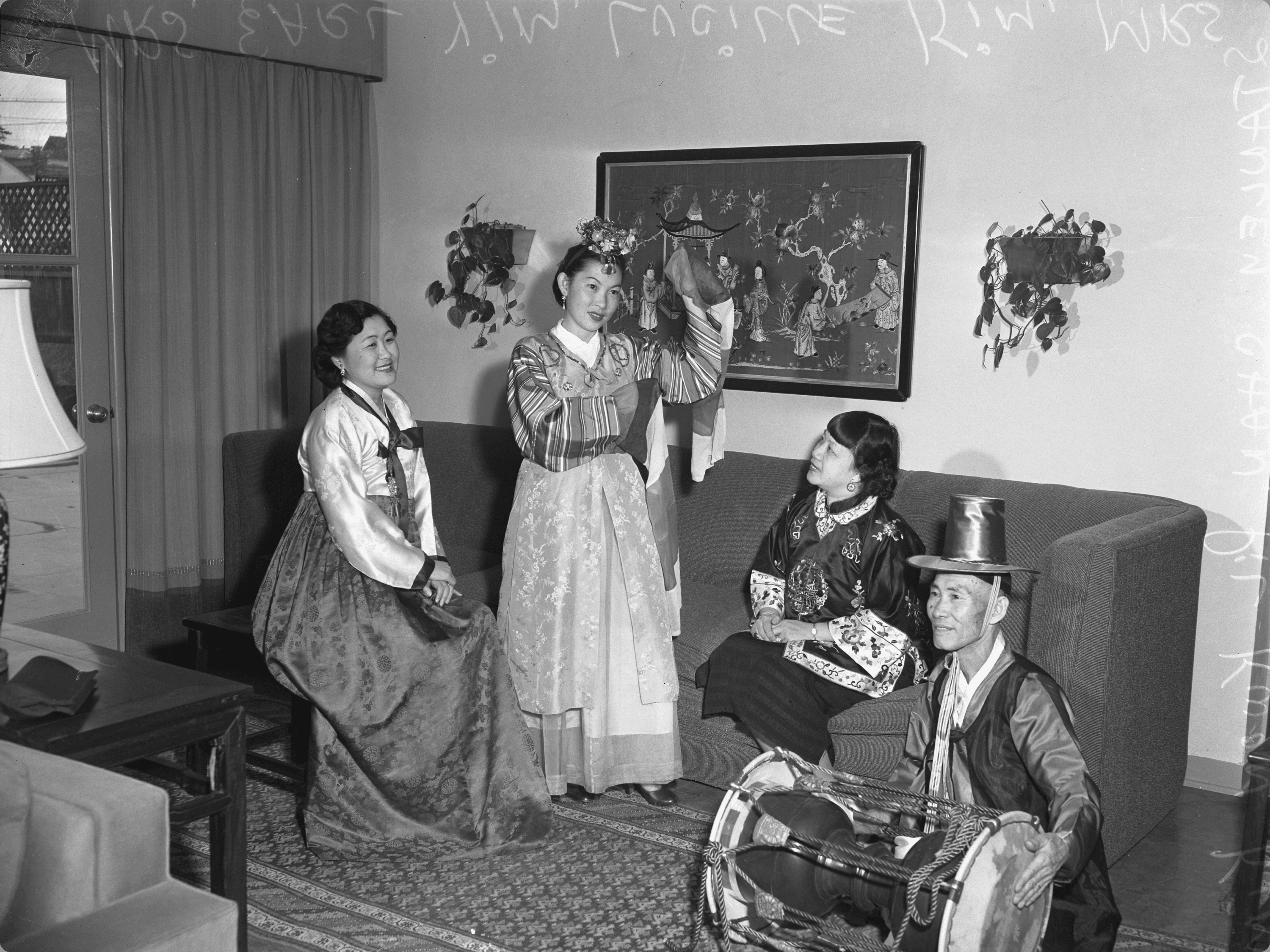 Members of a Korean American women's group in traditional Korean clothing standing with a Korean drummer in Los Angeles, California, circa 1952.